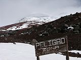 Ecuador Cotopaxi 02-10 Glacier From Jose Ribas Refuge The clouds briefly parted allowing us a brief view of the glacier at 5000m beginning just 30 minutes walk from the Jose Ribas Refuge (4800m). The hike down from the refuge is very fast, taking only 10-15 minutes depending on how much you can bend your knees to slide down the old lava flow is covered in a thick layer of volcanic dust and ash. Once back at Tambopaxi we enjoyed a glass of white wine.